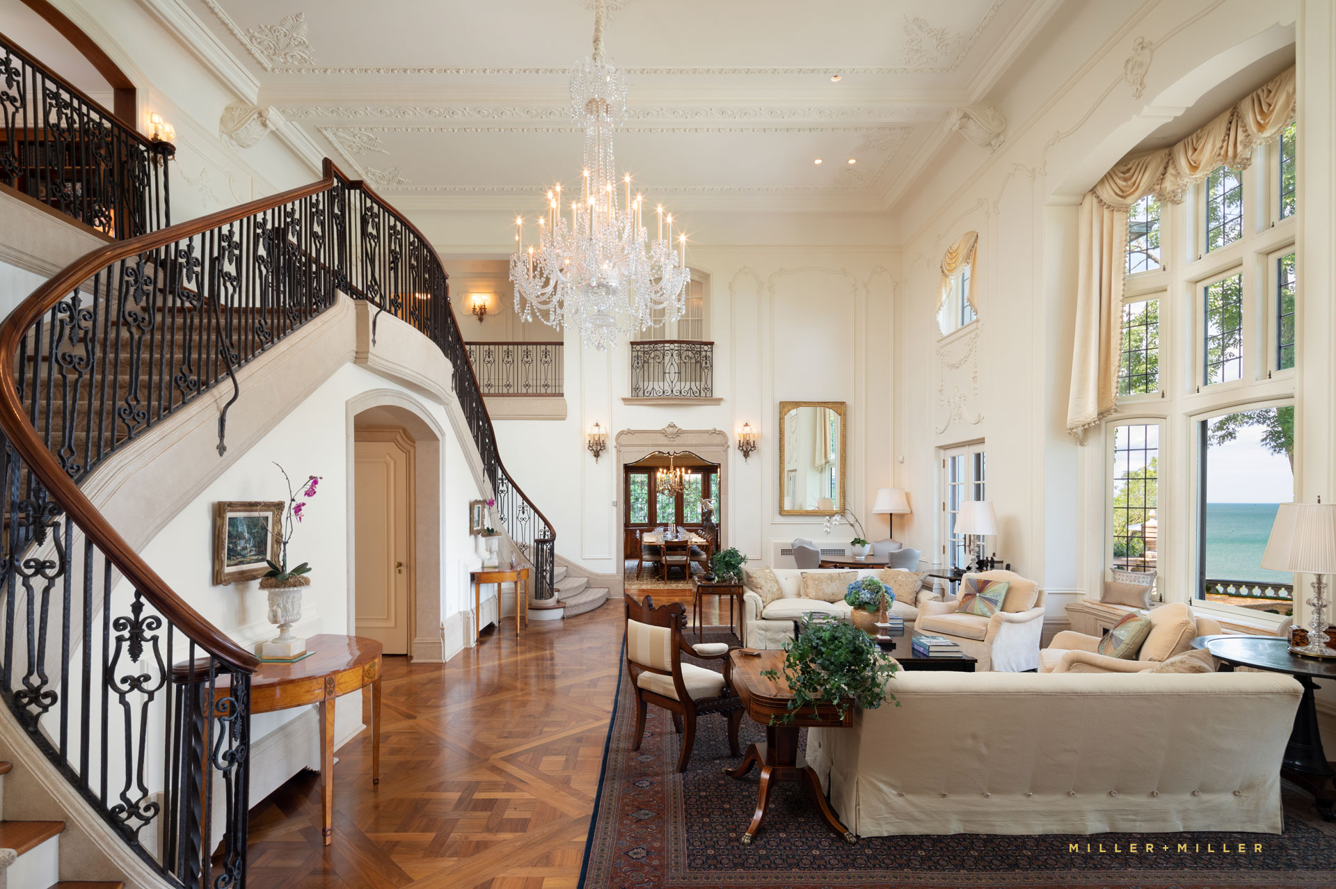 double wrought iron staircase french doors Lake Michigan waterfront home french inspired Venetian crystal chandelier juliette balcony